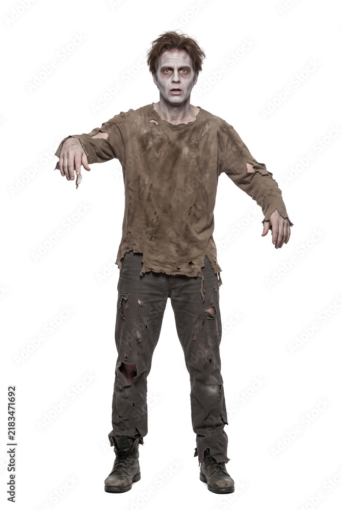 Fototapeta premium A person dressed as a zombie stands alone on a white background. The outfit is tattered, and the makeup creates a spooky effect. This is fitting for Halloween celebrations