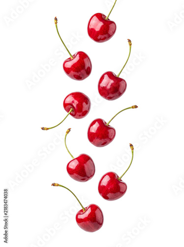 Foto Bright red cherries with green stems gracefully falling, symbolizing fresh fruit and healthy summer snacks
