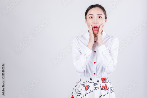 Фотография Surprised woman with hands on cheeks and wide-eyed open-mouth expression