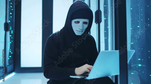 Anonymous Hacker Using Laptop Inside State Of The Art Data Center