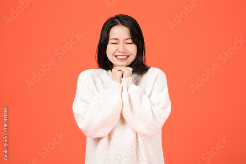 Fotografía Happy Asian woman smiling with eyes closed and clasped hands