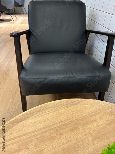 Quadro su tela This appears to be an armchair featuring a mid-century modern design with dark wooden armrests and black upholstery