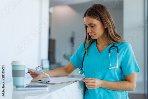Healthcare professional reviewing medical records at clinic reception