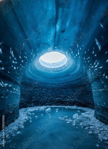 Blue Ice Cave Interior, Frozen Tunnel with Natural Cavern, Glacial Texture, Cold Atmosphere, Watery Reflection, Arctic Concept, Abstract Ice Formation, Winter Scenery