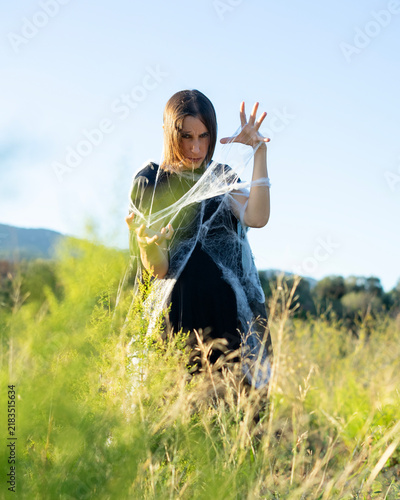 Obraz na płótnie Woman Posing with Spiderweb in Field