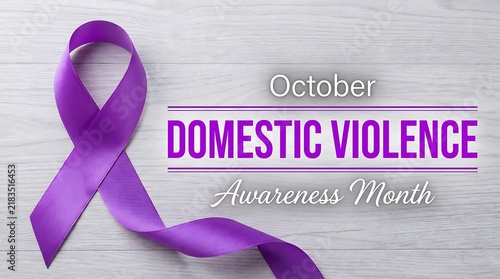 Purple ribbon for Domestic Violence Awareness Month on a white wooden background.
