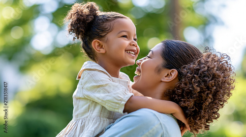 African mother and daughter laughing together in a sunny outdoor garden, joyful family bonding, playful parenting, multicultural family, authentic lifestyle, natural sunlight,