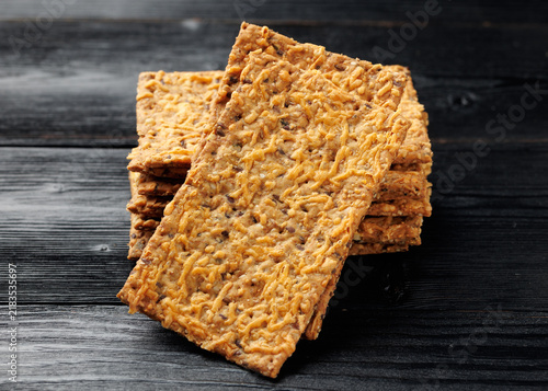 Bild auf Leinwand Wholegrain Cheese Crispbread with Mixed Seeds on Dark Background