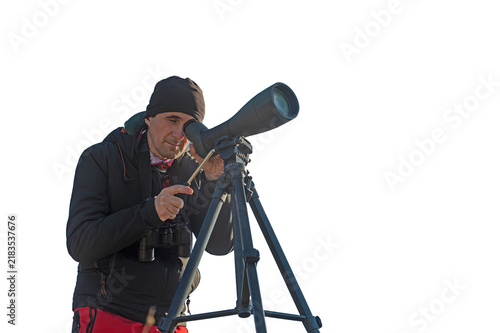 Fotografía A male observer using a spotting scope (observation telescope) mounted on a tripod to observe birds and nature through a transparent lens