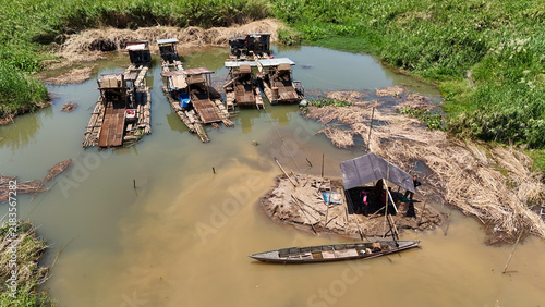 Konstfotografi Small scale mining boats and makeshift shelters situated on a river in South Kal