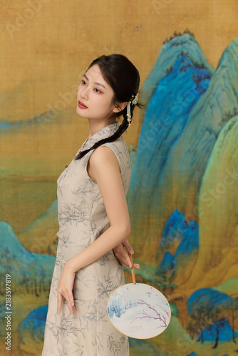 Foto Young Woman in Traditional Chinese Qipao Holding Round Fan