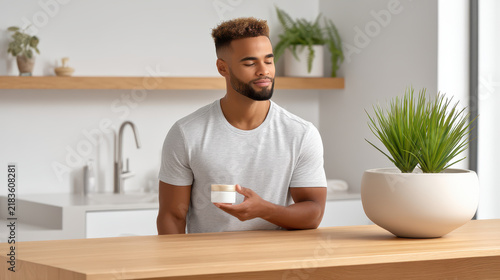 Man enjoys clinical skincare beauty science with moisturizing cream in bright modern kitchen showing calm and satisfaction