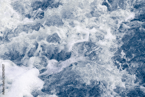 Cold swirling river current with choppy blue water and white foam.
