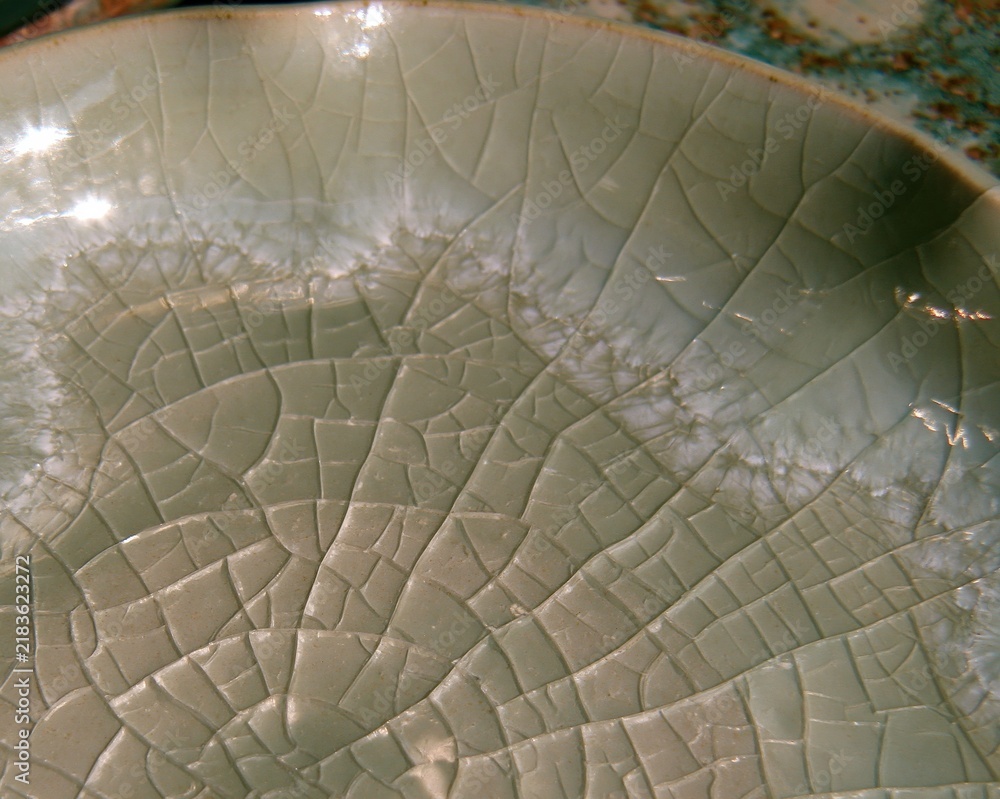 Obraz premium Ceramic glaze surface with a crazed crackle texture and pale sage green tones, featuring tactile pooled edges for a material sample background