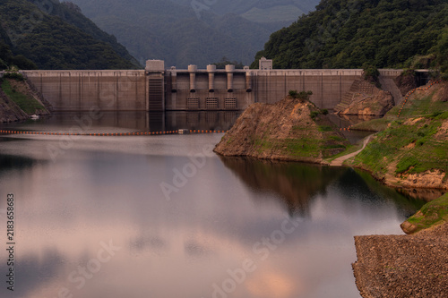 夕暮れ時にたたずむ八ッ場ダムの堤体と穏やかな水面