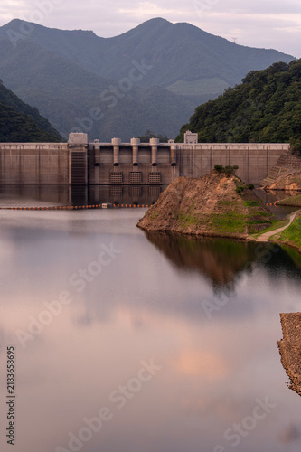 夕暮れ時にたたずむ八ッ場ダムの堤体と穏やかな水面