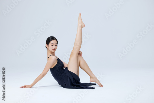 Fotografie Contemporary female dancer posing on studio floor with raised leg