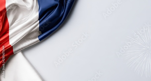 Smooth, flowing French flag drapes across a bright background with subtle fireworks