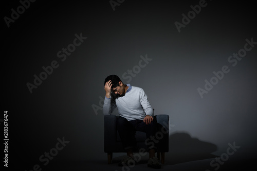 Foto Pensive Man in Chair Deep in Thought