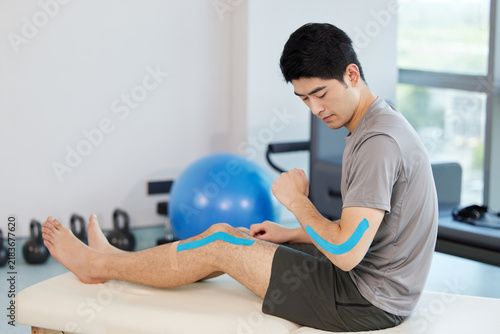 Konstfotografi Physical therapy knee taping Asian man