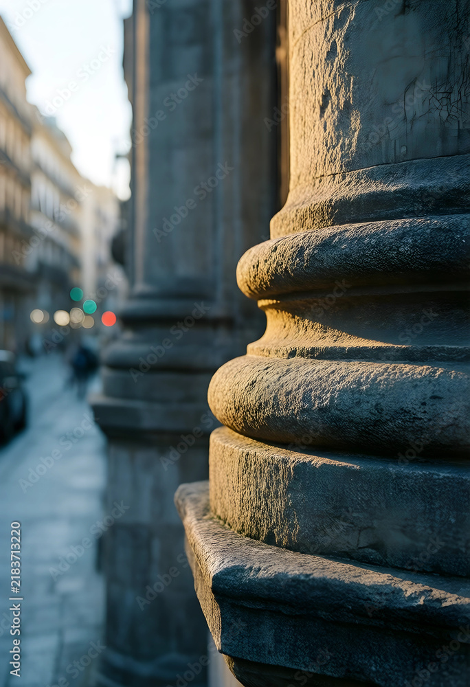 Obraz premium Urban architecture and heritage preservation, stone column detail with warm sunset light on a historic city street with blurred background