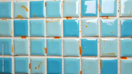 Small square ceramic tiles in bright sky blue with glossy finish arranged in geometric pattern for modern interior wall decoration background design concept photography with clean texture elements sty