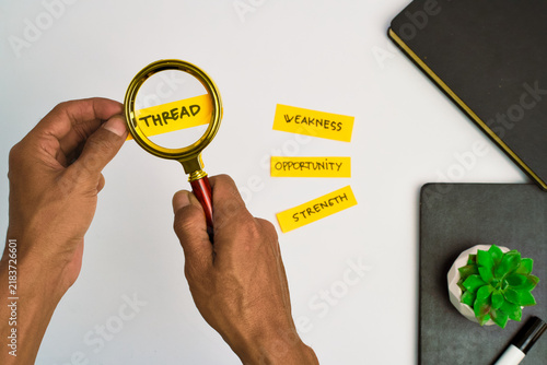 Magnifying glass examining a sticky note with the word thread written on it