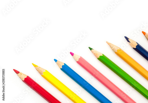 Colorful wooden pencils arranged diagonally on isolated white background with copy space.