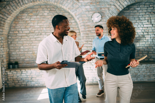 Diverse coworkers chatting and collaborating in a casual office space during a team meeting