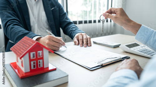 Canvastavla Real estate broker agent holding filing keys to the customer after signing renta