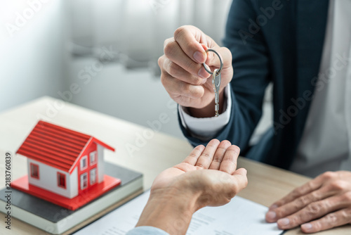 Foto Real estate broker agent holding filing keys to the customer after signing renta
