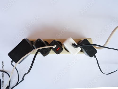 Fotografie Overloaded Power Strip with Multiple Chargers and Plug Adapters