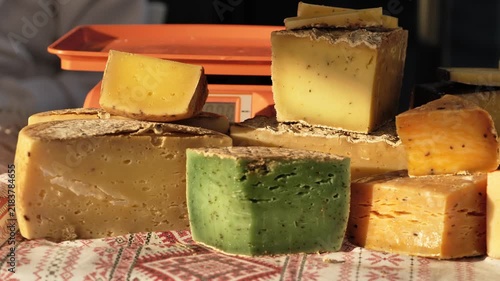 Artisan cheese selection displayed on a market stall with weighing scale