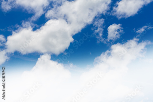 Beautiful blue sky with fluffy white cumulus clouds and abstract gradient white bottom border.