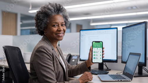 Tech-Savvy Senior Professional: A confident senior Black woman, with elegant grey hair, smiles warmly as she displays a smartphone with a wellness app.