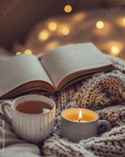 Cozy Hygge Reading Nook with Warm Tea, Candlelight, Open Book and Knit Blanket