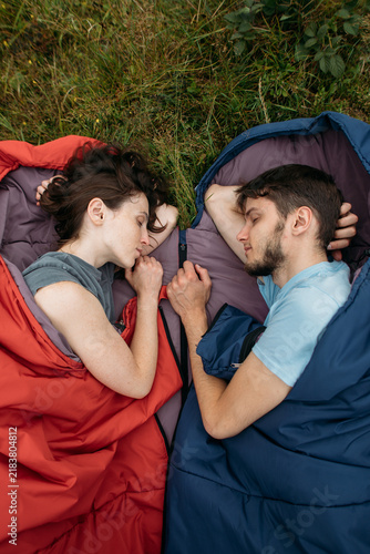 young couple in sleeping bags for nature and hiking