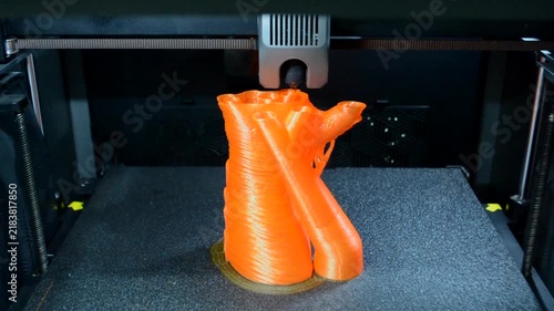Process printing on 3D printer. The 3D printing process from molten plastic orange color. 3D printing technology. FDM technologies. Fused Deposition Modeling. Additive manufacturing.