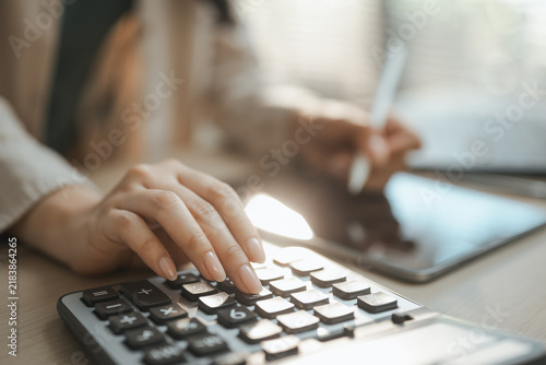 Cuadro en lienzo Corporate finance directs capital towards roi from investment as fingers press black keys, checking corporate finance and capital for roi from investment beside a tablet and white stylus in sunlight