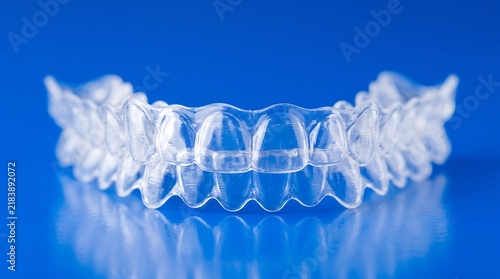 Obraz na płótnie Clear dental aligners on a blue reflective surface