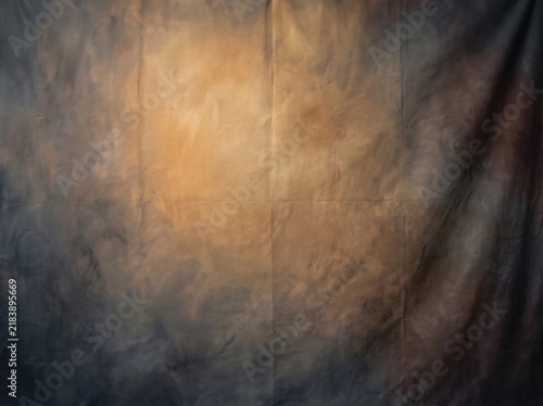 Textured studio photography background with dramatic moody lighting and warm gold glow