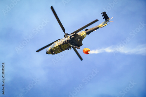 Firefighting helicopter carrying a water tank
