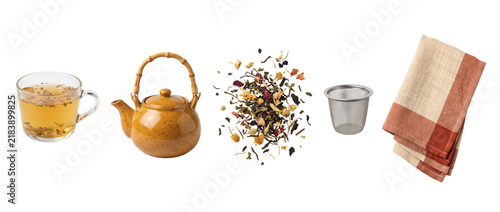 Herbal tea collection, a glass cup accompanies an amber teapot, loose leaves and a metal infuser. A folded cream and rust cloth completes the separated brewing accessories on transparent space.