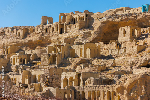 Historic old Izadkhast village in Iran with ancient adobe houses built on a rocky cliff, traditional Persian architecture and desert landscape. Panoramic view