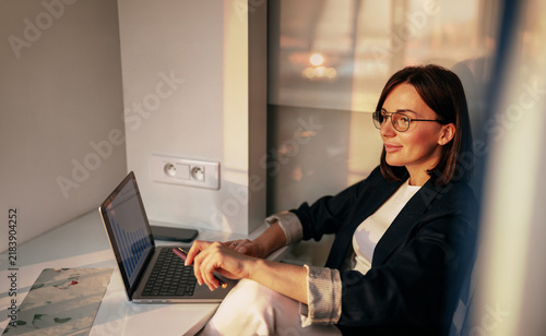 Businesswoman working on a laptop at a window counter desk