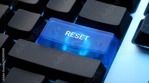 Obraz na płótnie Glowing blue reset button on computer keyboard representing system restart or technology reboot concept.
