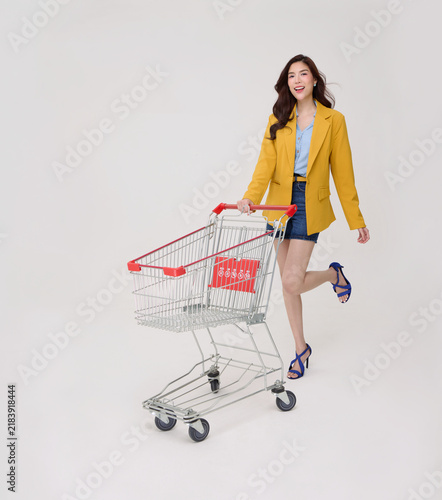 Asian Woman pushing shopping cart representing retail shopping consumer choice supermarket convenience smart spending seasonal sales and confident modern lifestyle.