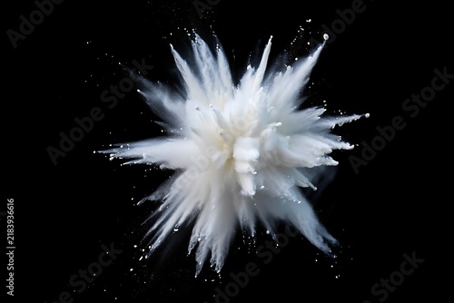 Explosion of fine white powder creating a dynamic starburst pattern against solid dark black backgro