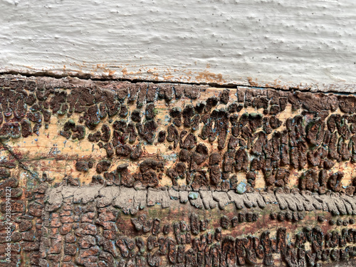 Full frame background texture of weathered old wood planks with heavily peeling cracked brown paint