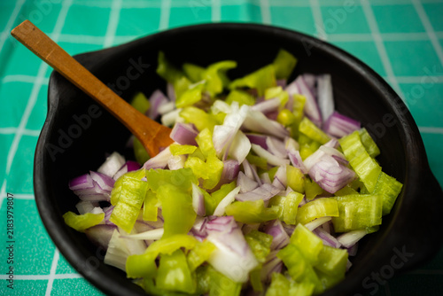 Фотография Chopped Green Peppers and Red Onions Mix in Clay Bowl with Spoon